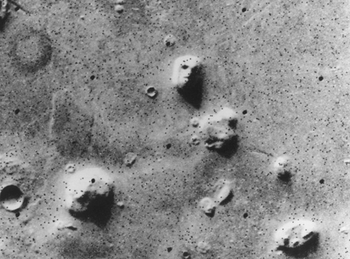 grayscale image of Martian landscape, including a rock formation which resembles a face