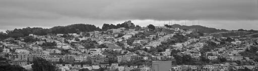 A panoramic view of a hillside in San Francisco, covered in small mid-century residential houses.