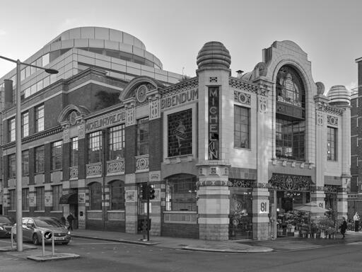 An ornate, 2 story Art Nouveau building, heavily ornamented with tire-themed features and stained glass windows featuring the "Michelin Man" character in different poses.