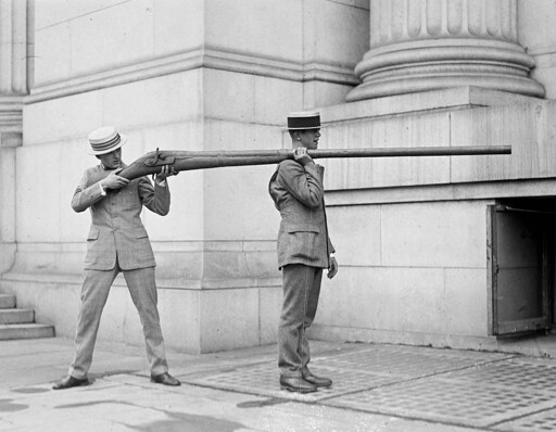 Two men posing with a 'Punt Gun', a kind of shotgun for hunting waterfowl in large quantities, 1923