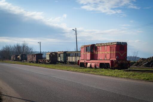 Shot on the vehicles from across the road, showing the locomotive and various coaches and platforms