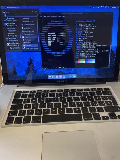 L'immagine mostra uno screenshot di un desktop di computer con una finestra di terminale in primo piano. Il terminale mostra un output di testo che include caratteri ripetuti ("o" e "c"). Sulla sinistra, una barra laterale mostra un menu di applicazioni suddiviso in categorie: "Favorites", "Recently Used", "All Applications" con sottocategorie come "Archiving", "Development", "Editors", "Graphics" e "Internet". Il desktop ha uno sfondo blu scuro con un logo in basso a sinistra. La barra superiore mostra informazioni sullo stato del sistema, tra cui l'ora (11:41 AM).

Alt-text: L'immagine mostra uno screenshot di un desktop di computer. Una finestra di terminale in primo piano mostra il testo "niclinux-macbookpro51", seguito da righe di output che consistono in una sequenza di "o" e "c". Una barra laterale a sinistra elenca diverse categorie di applicazioni, tra cui "Favorites", "Recently Used", "All Applications" e sottocategorie. Il desktop ha uno sfondo blu scuro. Sulla barra superiore è presente l'indicatore di ora "11:41 AM".
