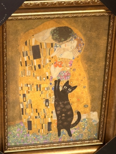 Gustav Klimt's The Kiss in a gold decorative frame in a box at TJ Max, there is a large black cat pawing for attention from the lovers in the painting. The cat was added to the painting by Ai. 